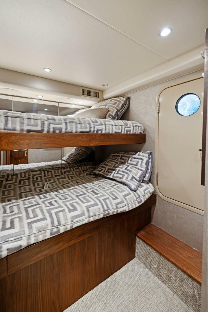 a bed with a white sheet and a wooden headboard aboard PLAN B Yacht for Sale