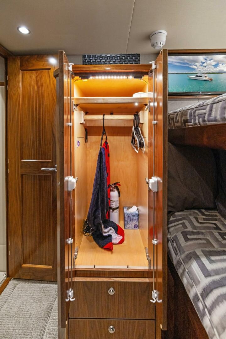 a closet with clothes on the door aboard PLAN B Yacht for Sale