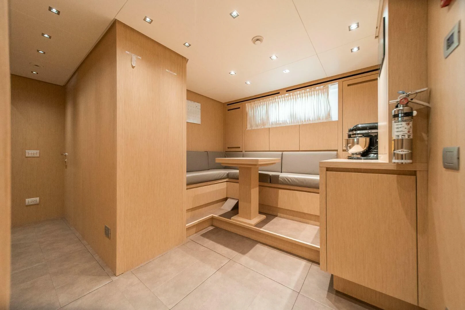 a room with a table and a bench aboard GENOA Yacht for Sale