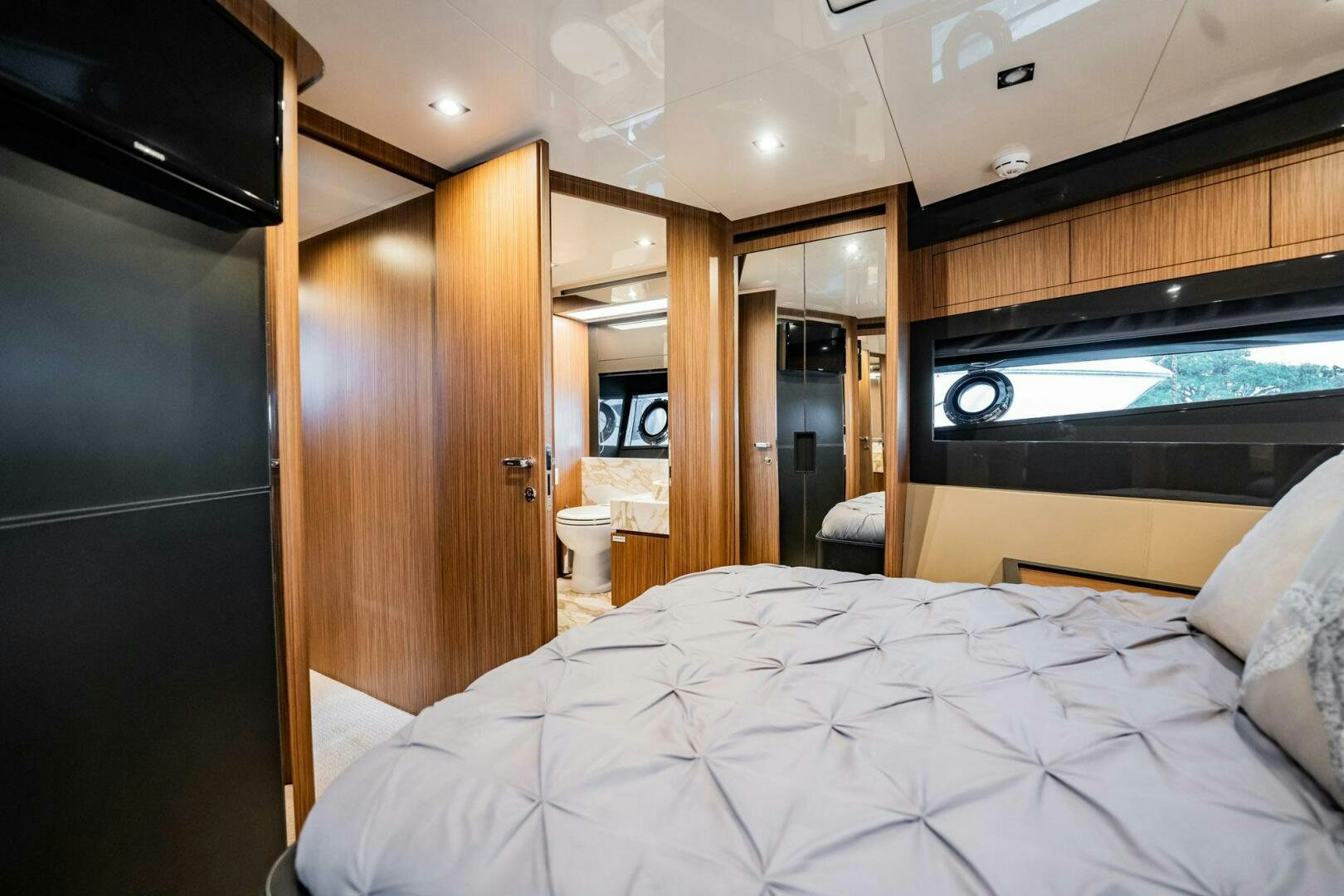 a bedroom with a bed and a wood cabinet aboard RECREATIONAL USE Yacht for Sale