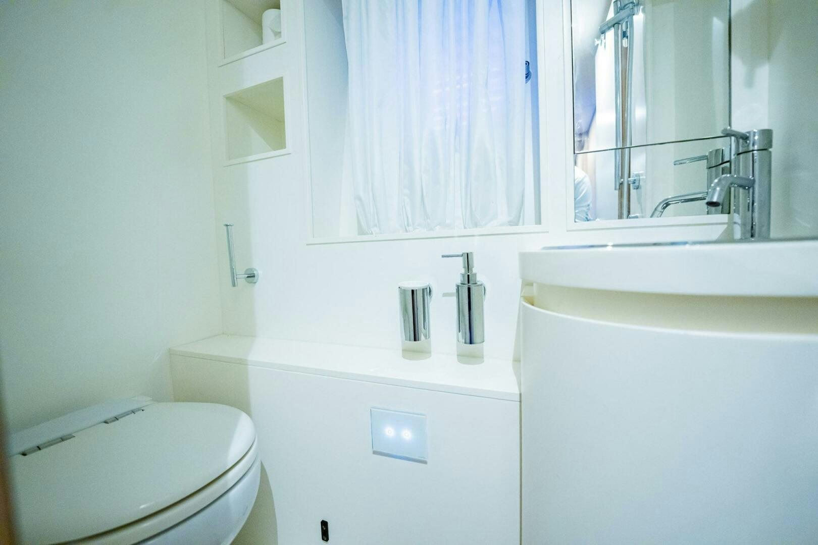 a bathroom with a toilet sink and a mirror aboard RECREATIONAL USE Yacht for Sale
