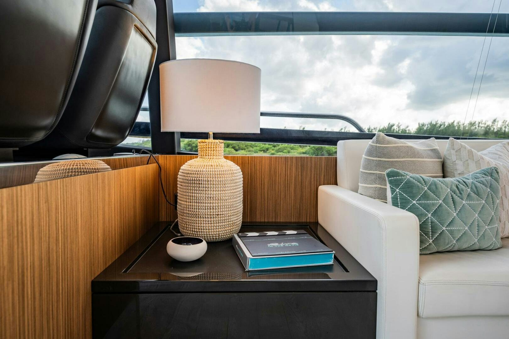 a lamp on a table in a room with a couch and a window aboard RECREATIONAL USE Yacht for Sale