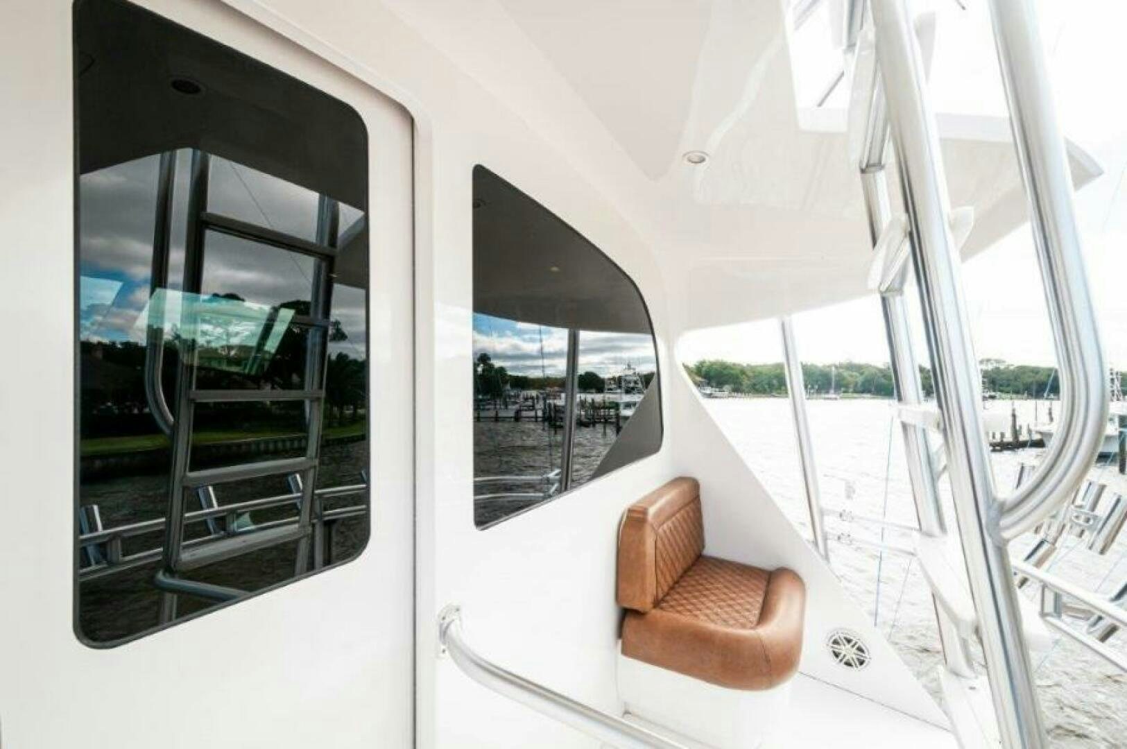 a white boat with a chair and a bench on the deck aboard POUR INTENTIONS Yacht for Sale