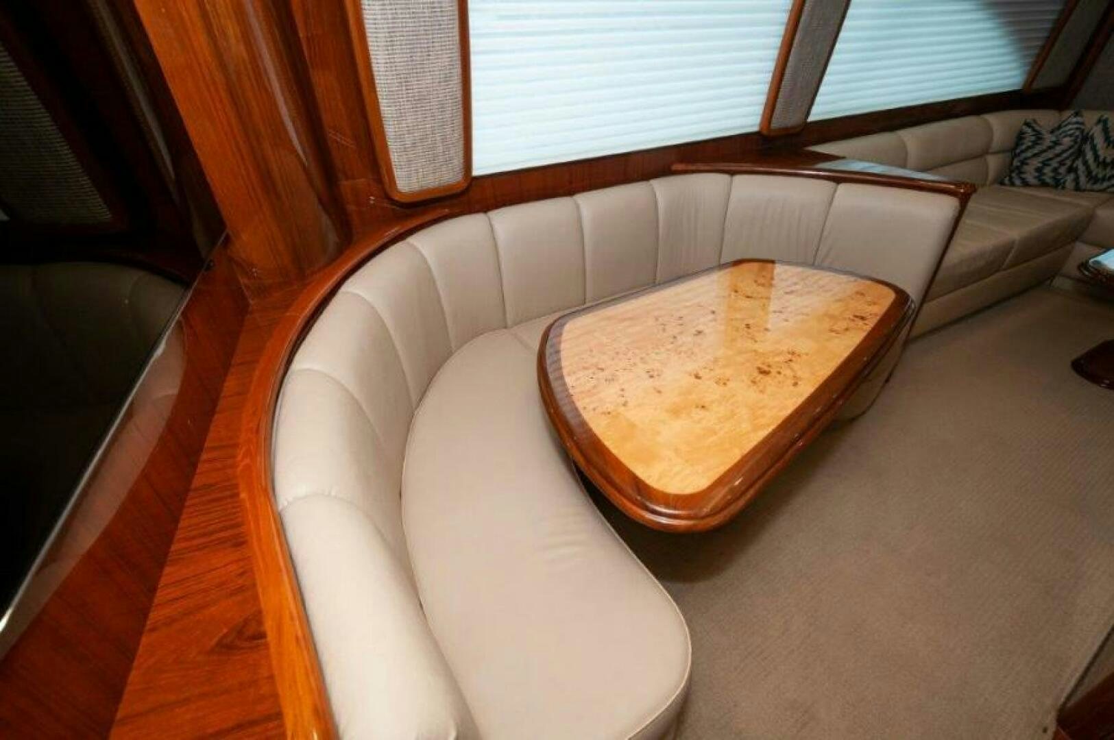 a couch with a pillow and a coffee table in the background aboard POUR INTENTIONS Yacht for Sale