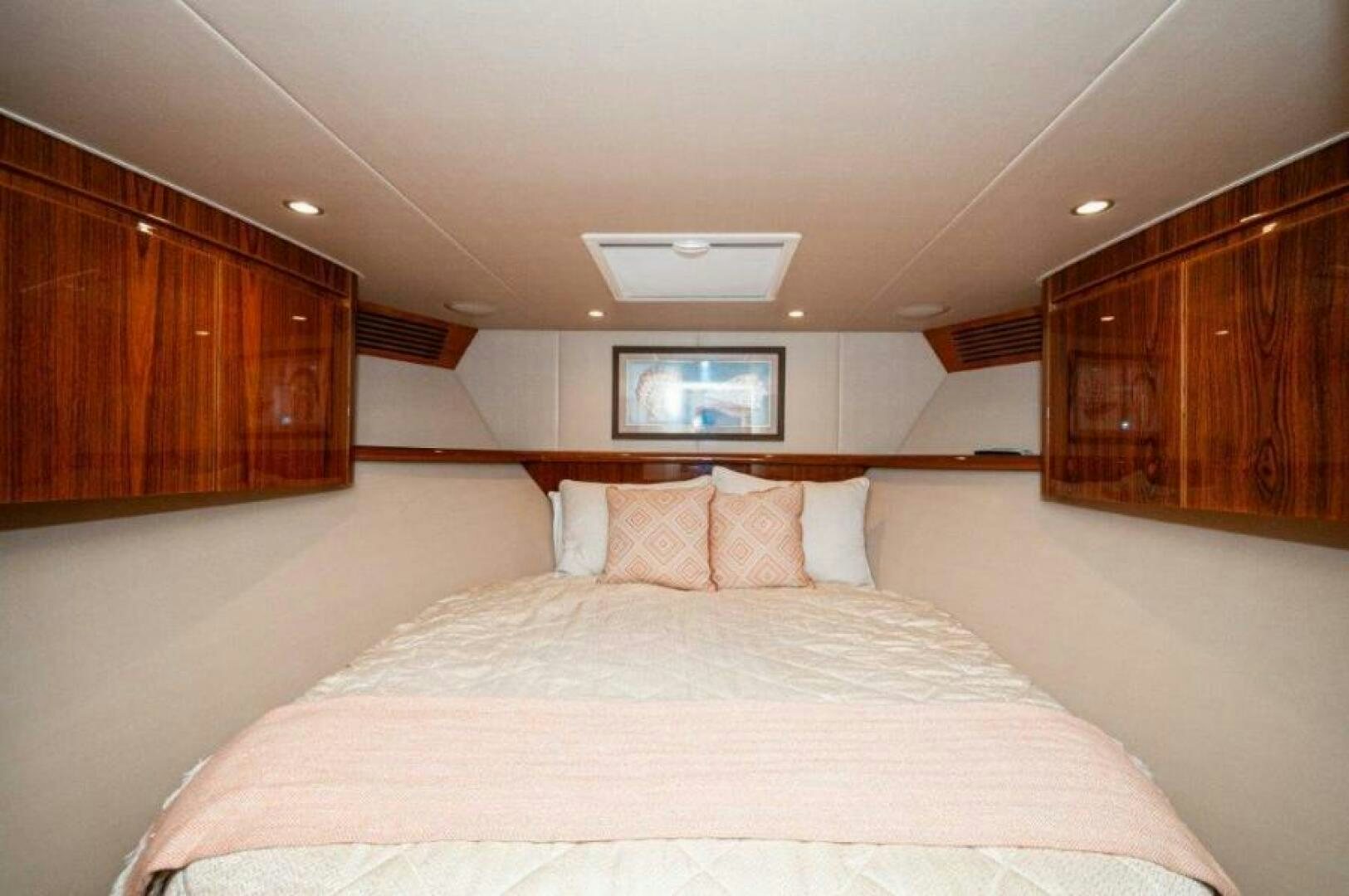 a bed with a white sheet and pillows aboard POUR INTENTIONS Yacht for Sale