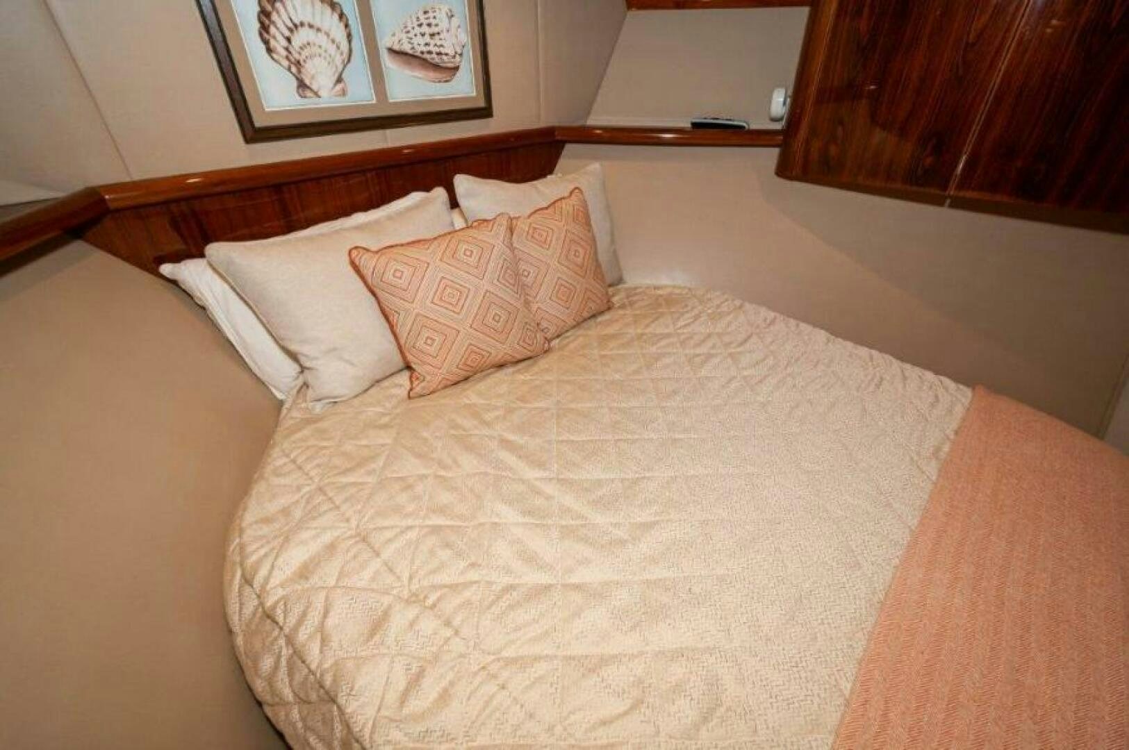 a bed with orange pillows aboard POUR INTENTIONS Yacht for Sale