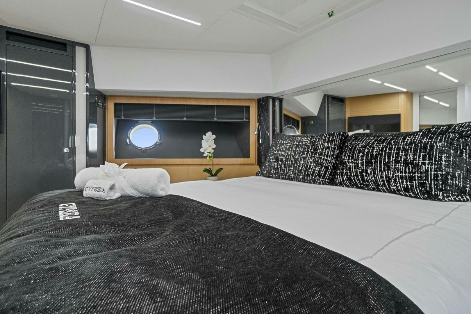 a bed with a black and white blanket on it aboard GYPSEA Yacht for Sale