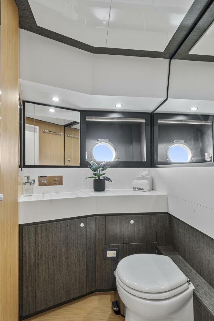 a bathroom with a toilet and a mirror aboard GYPSEA Yacht for Sale