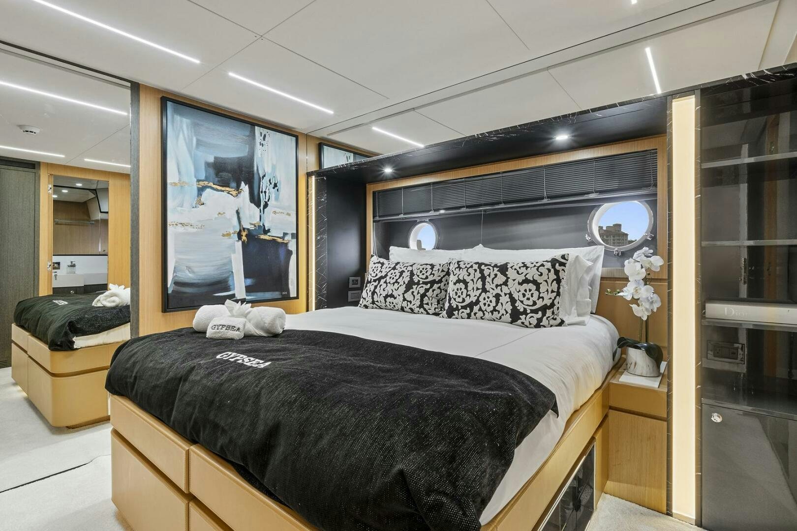 a bedroom with a bed and a mirror aboard GYPSEA Yacht for Sale