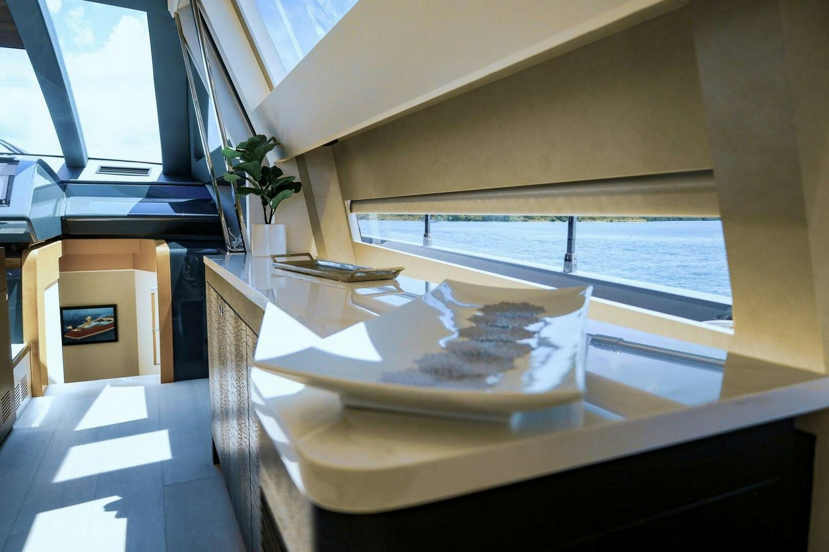 a room with a large window and a table with a plant on it aboard GYPSEA Yacht for Sale
