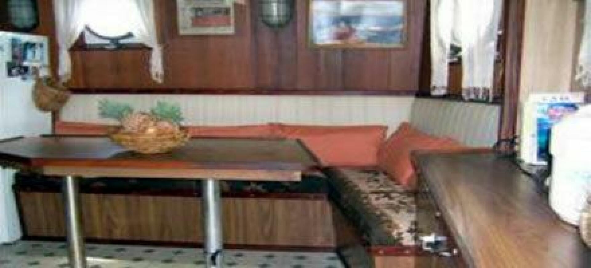a room with a table and couch aboard HAGANES Yacht for Sale