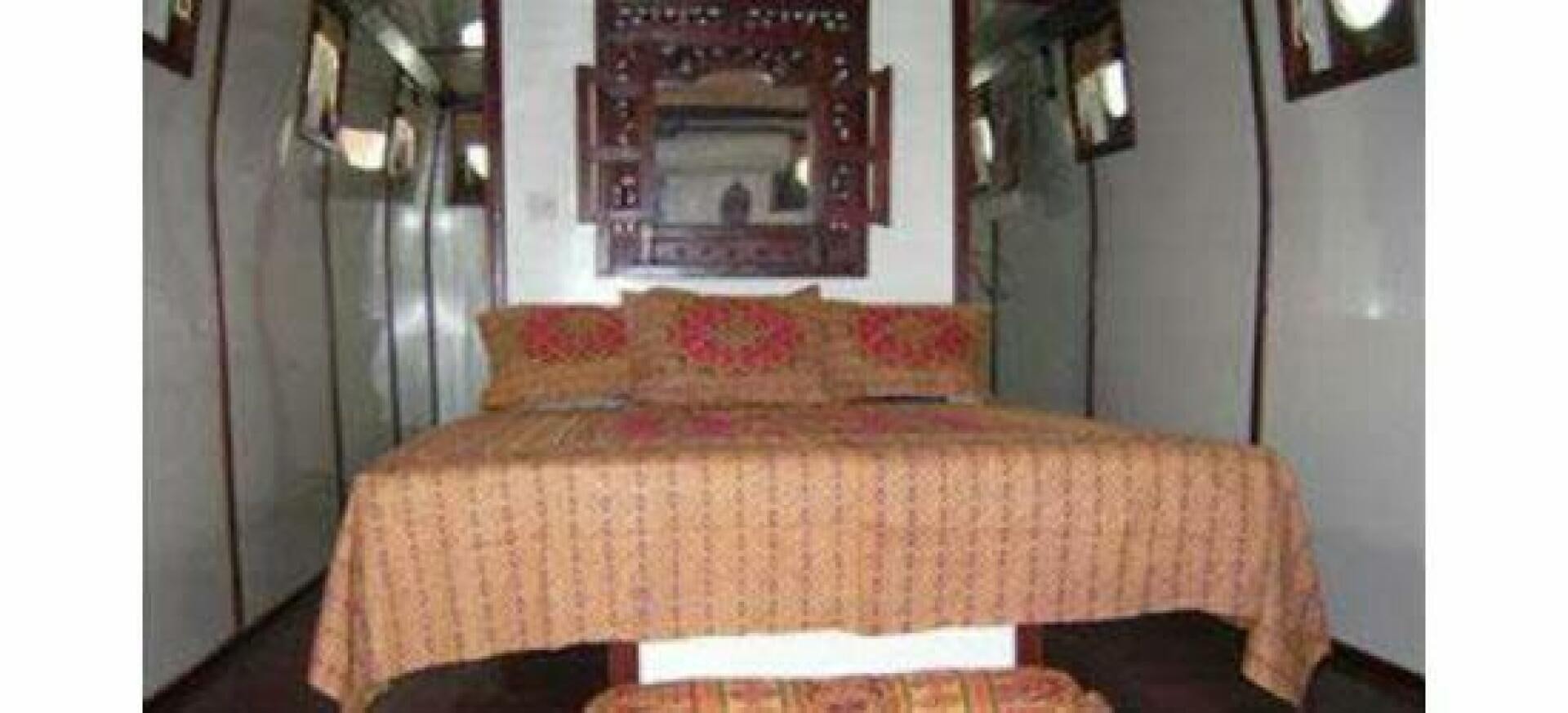 a bed with a red and yellow comforter aboard HAGANES Yacht for Sale