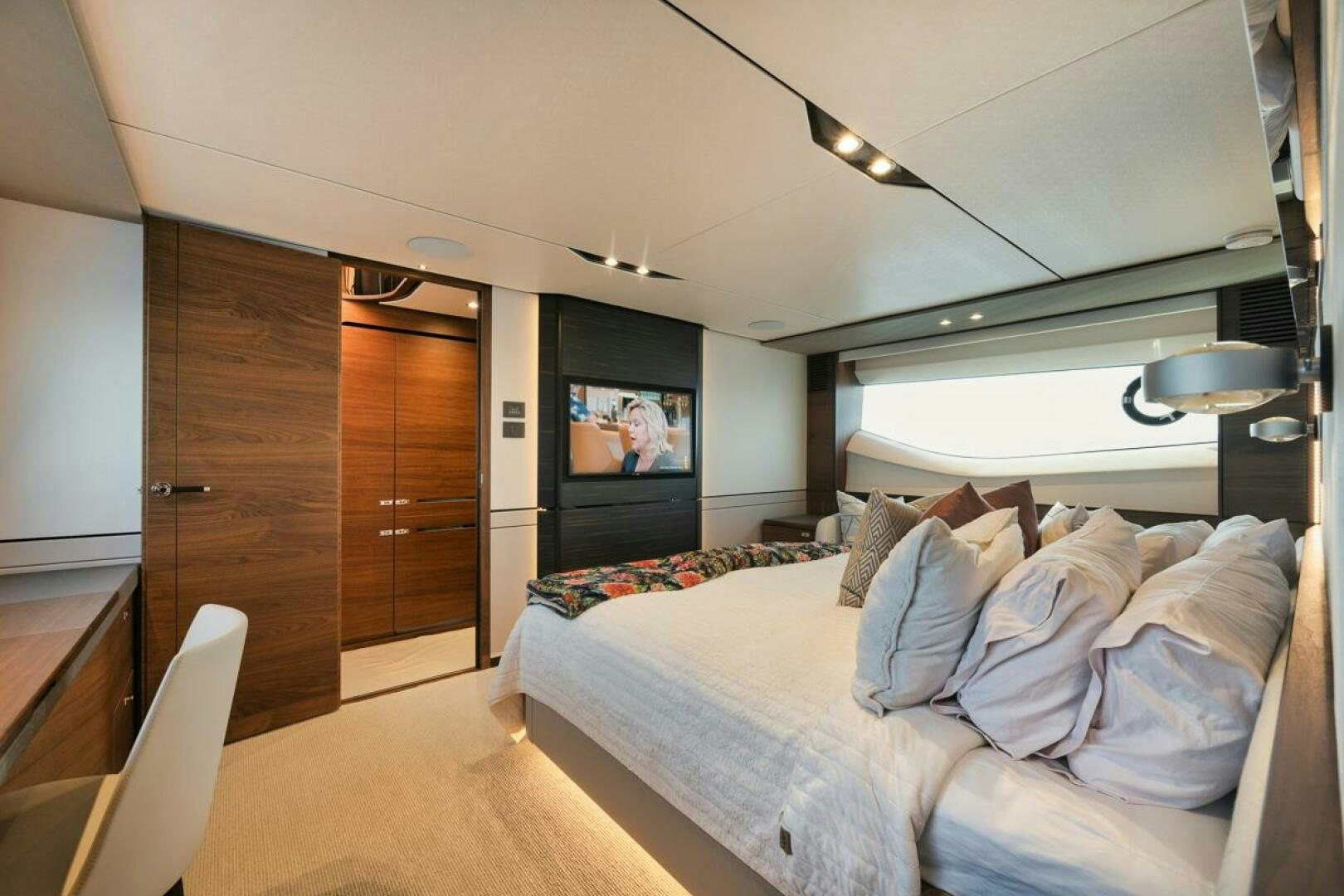 a bedroom with a bed and a television aboard HOOKED HER Yacht for Sale