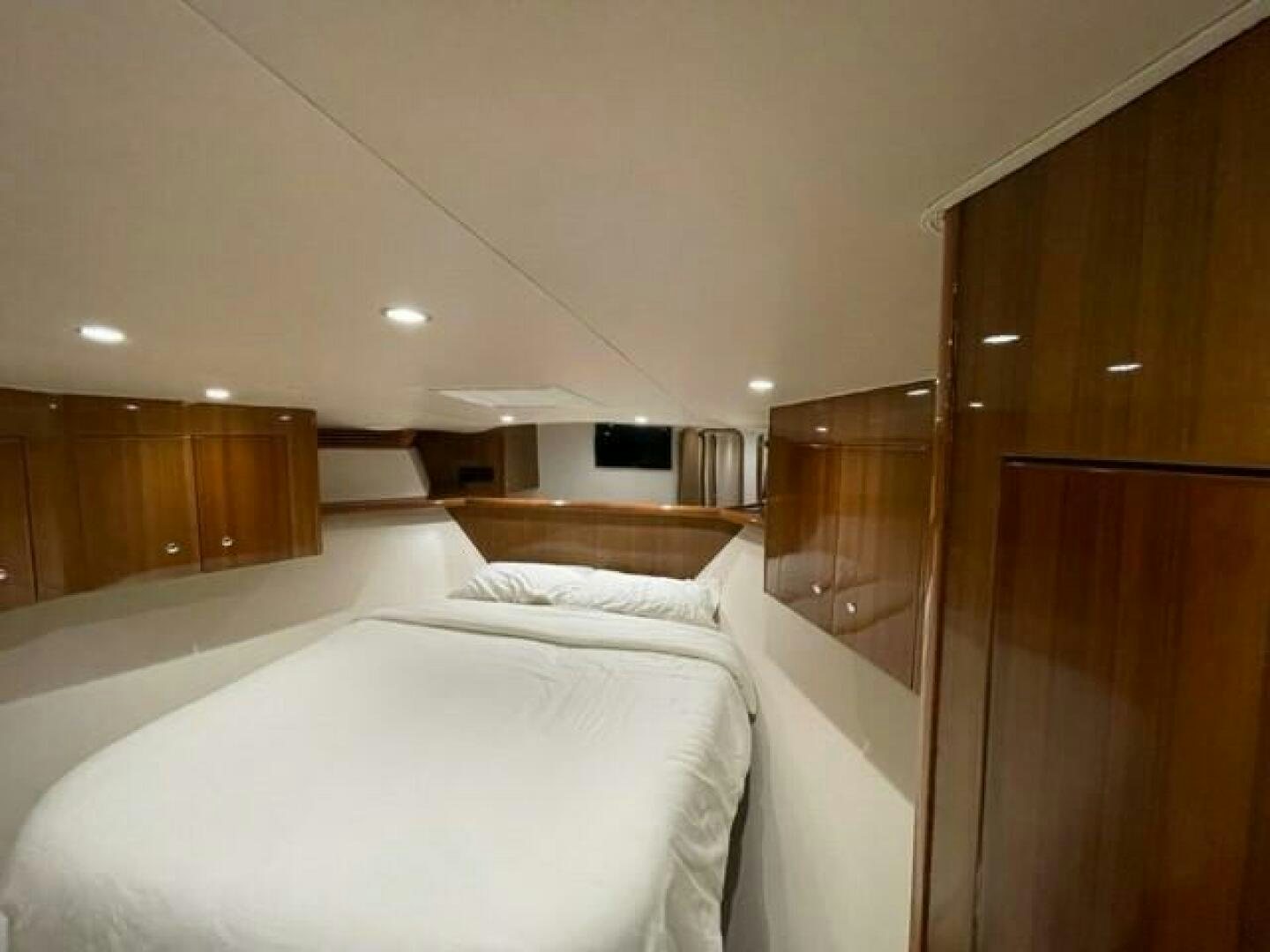 a bedroom with a bed and a wood cabinet aboard 6 C Yacht for Sale