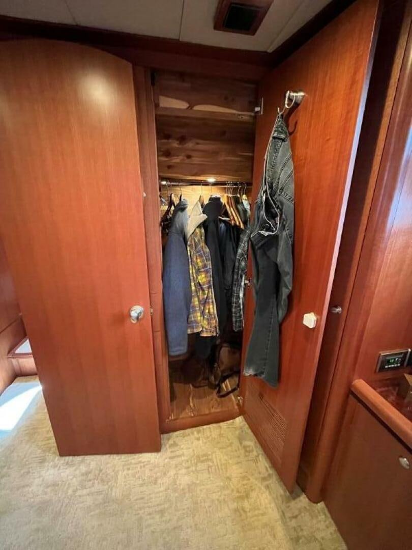 a closet with clothes on the door aboard SIG:PRN Yacht for Sale