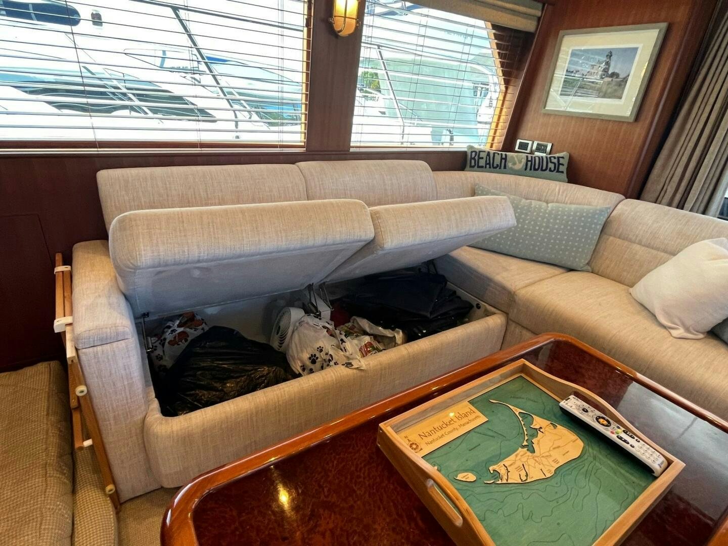 a couch with a table and a book on it aboard SIG:PRN Yacht for Sale