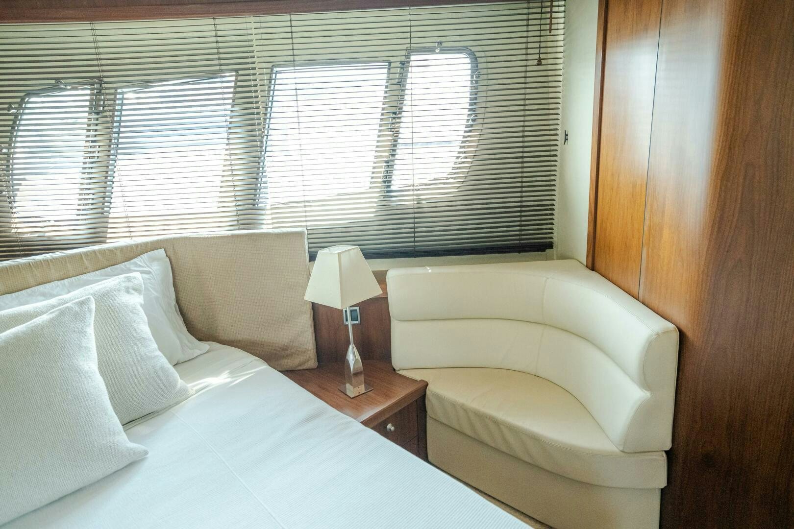 a bed with a lamp on it aboard BAR&CO Yacht for Sale