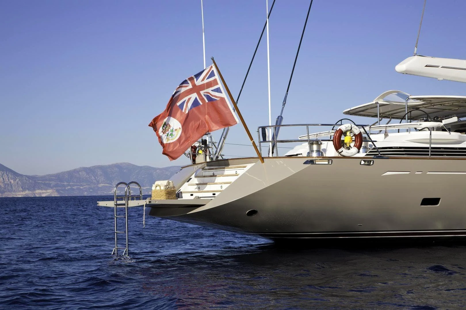 a boat with a flag on it aboard DESTINATION Yacht for Sale