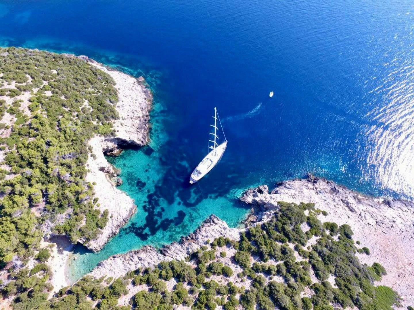 a beach with a beach and a boat in the water aboard DESTINATION Yacht for Sale