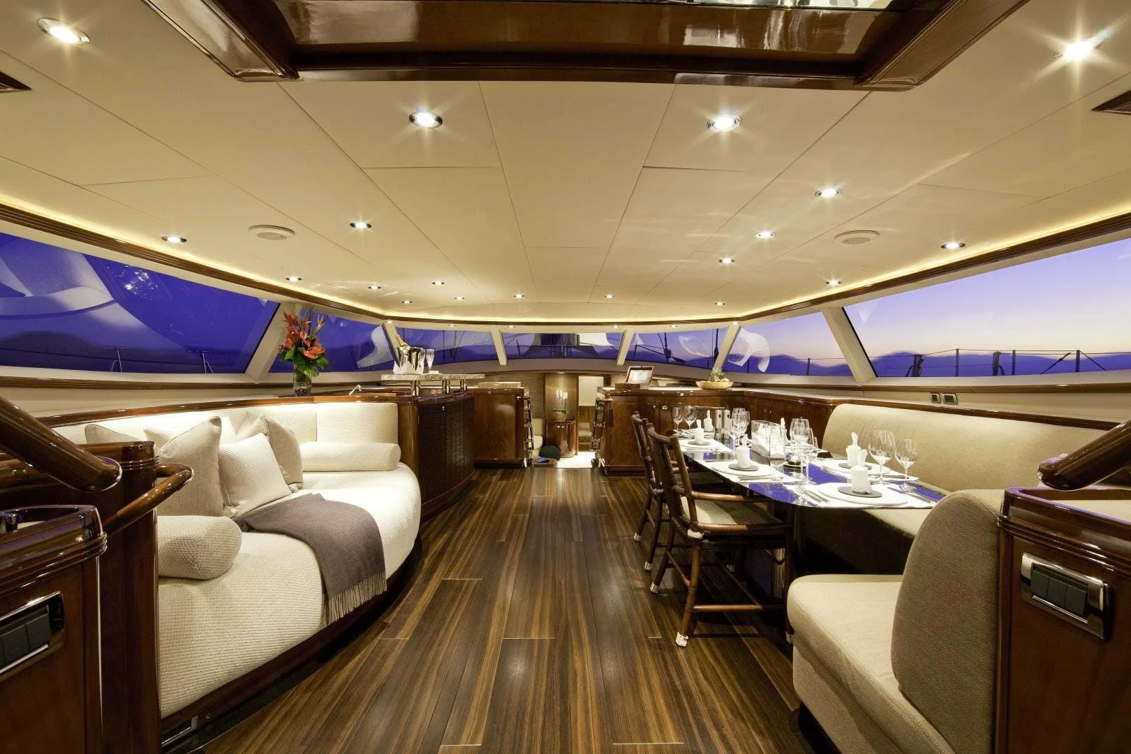 a room with a couch and a table with chairs and a television aboard DESTINATION Yacht for Sale