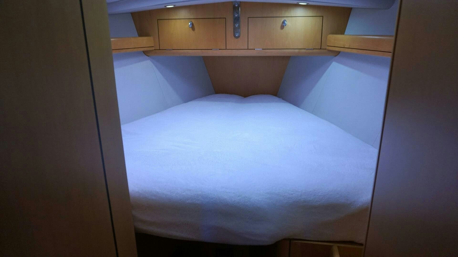 a bed with a white sheet aboard DOLCE VITA Yacht for Sale