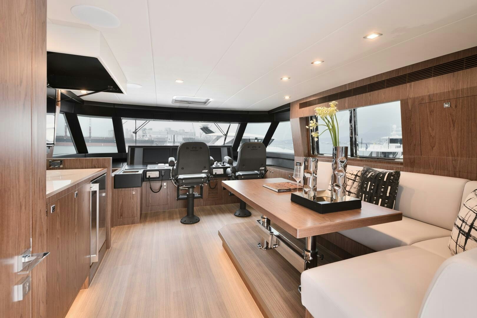 a room with a wood floor and a desk with a chair and a couch aboard V77S 610 Yacht for Sale