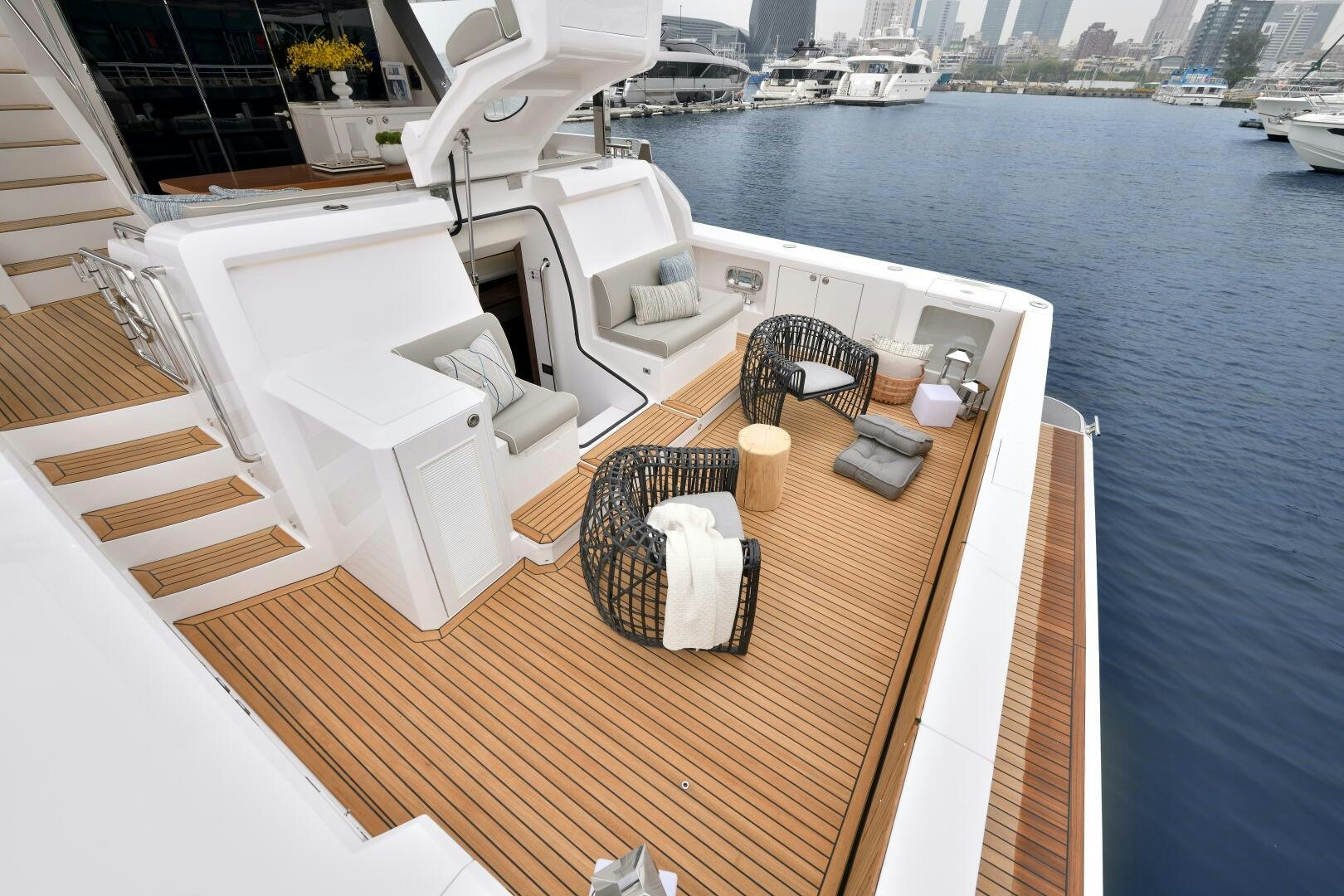 a deck with a table and chairs on it by a body of water aboard V77S 610 Yacht for Sale