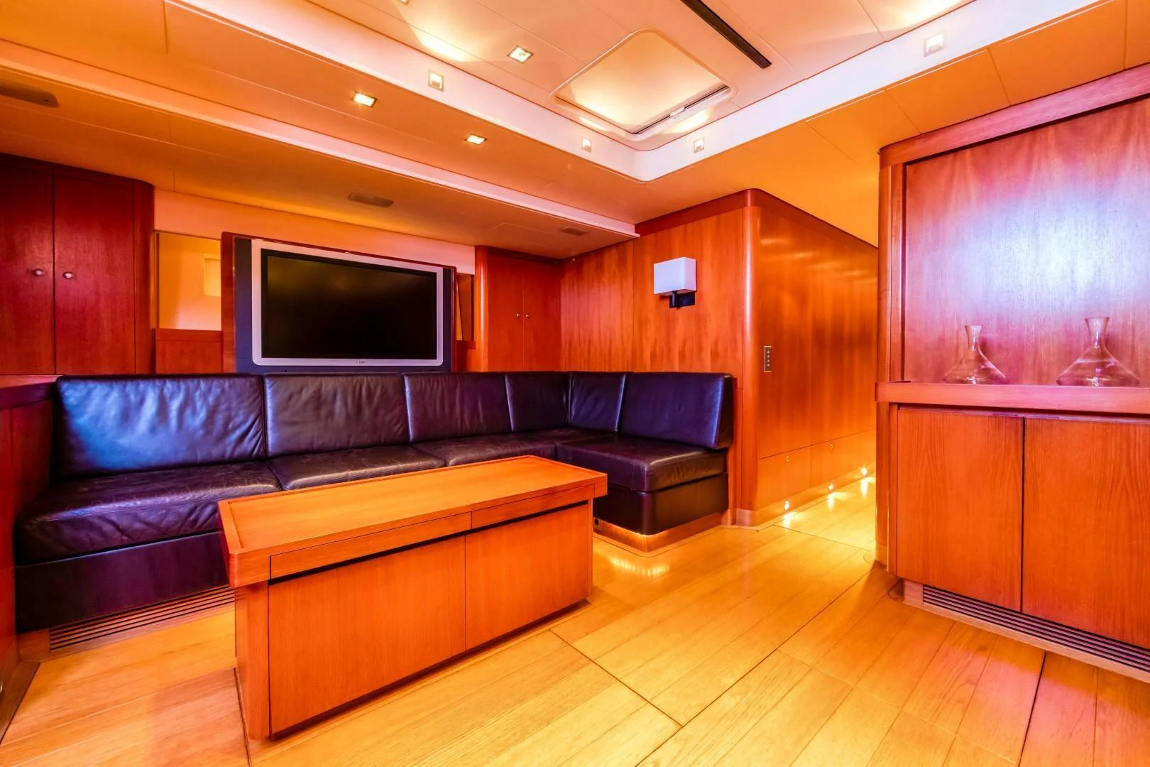 a living room with a leather couch aboard HOPPETOSSE Yacht for Sale