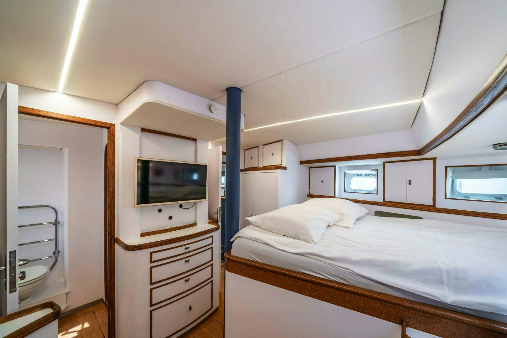 a bedroom with a bed and a television aboard ALTAIR Yacht for Sale