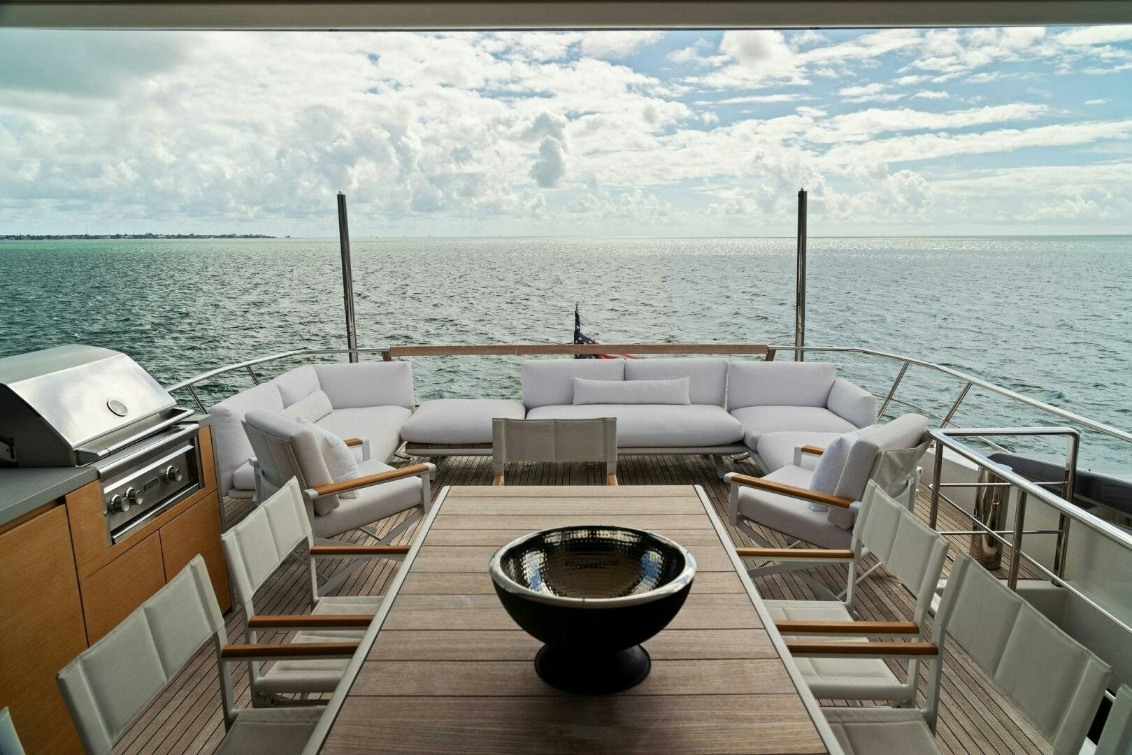 a deck with a large body of water and a large boat in the distance aboard GATSBY Yacht for Sale
