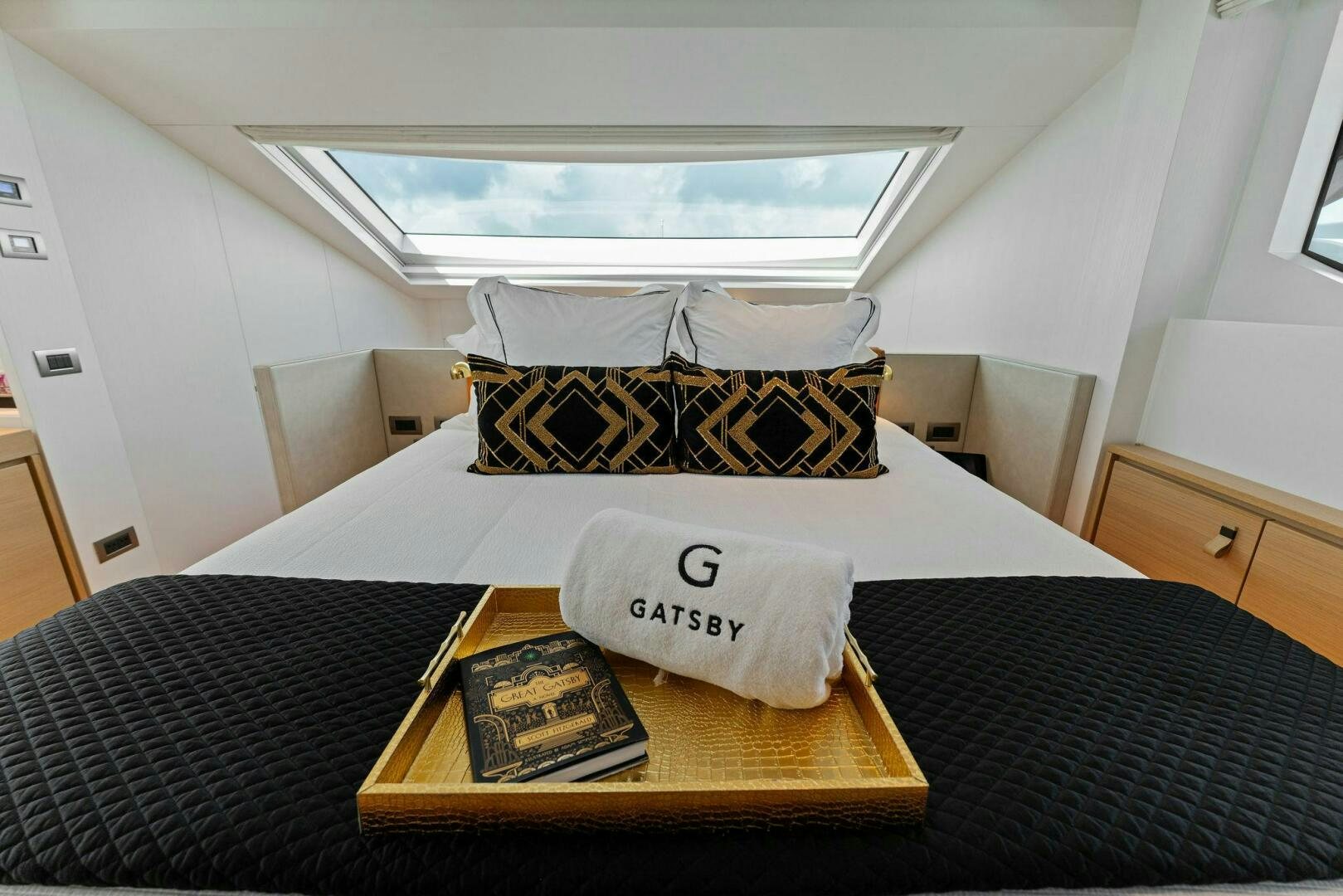 a bed with a pillow and a book on it aboard GATSBY Yacht for Sale