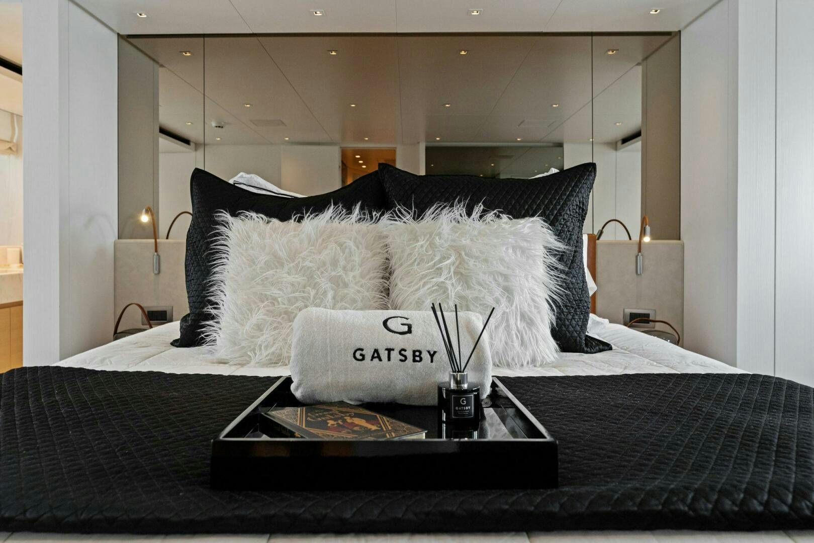 a bed with a black and white pillow and a white pillow on it aboard GATSBY Yacht for Sale