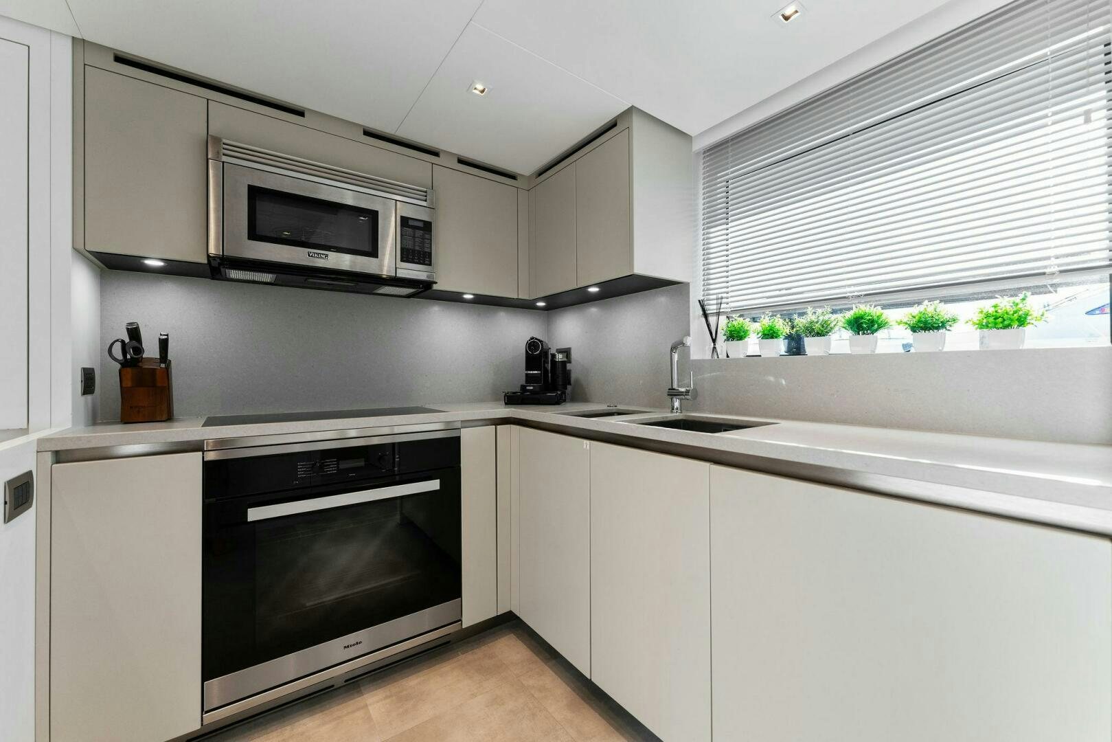 a kitchen with white cabinets aboard GATSBY Yacht for Sale