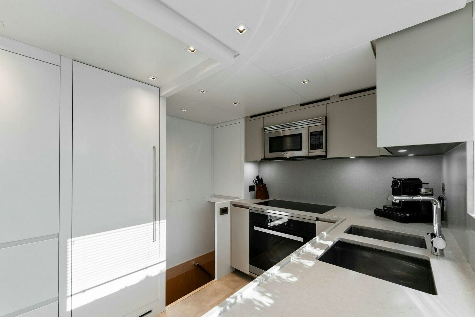 a kitchen with white cabinets aboard GATSBY Yacht for Sale