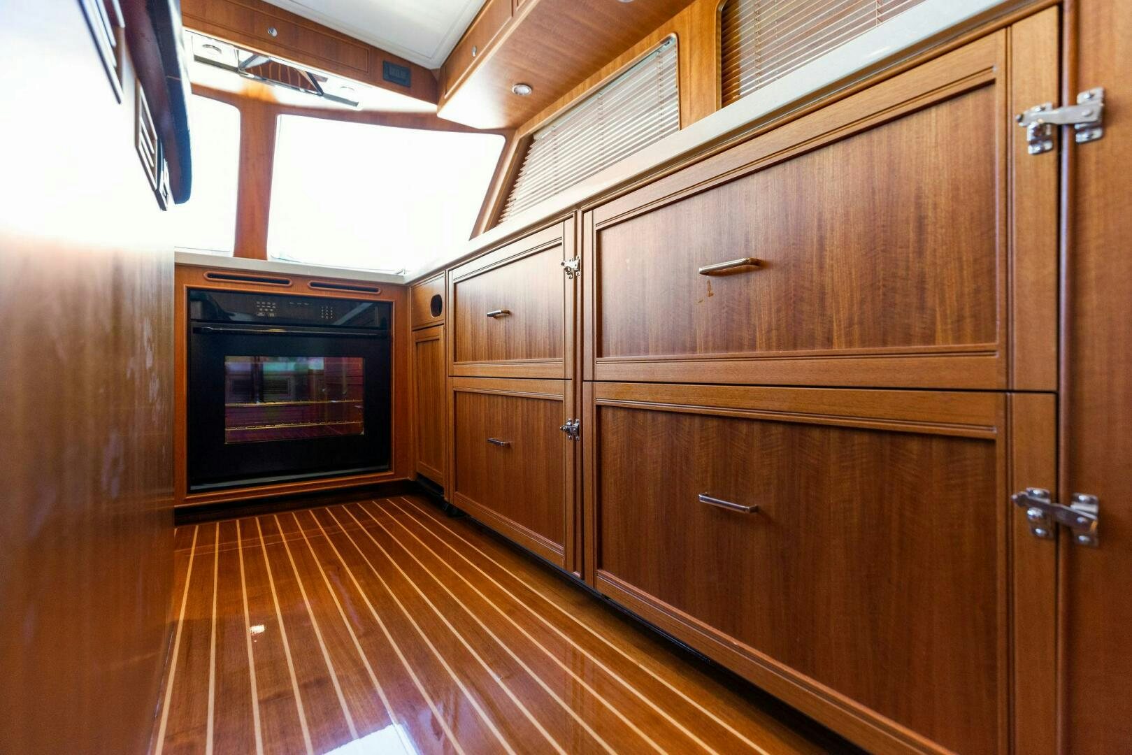 a kitchen with wooden cabinets aboard SUNZSET Yacht for Sale