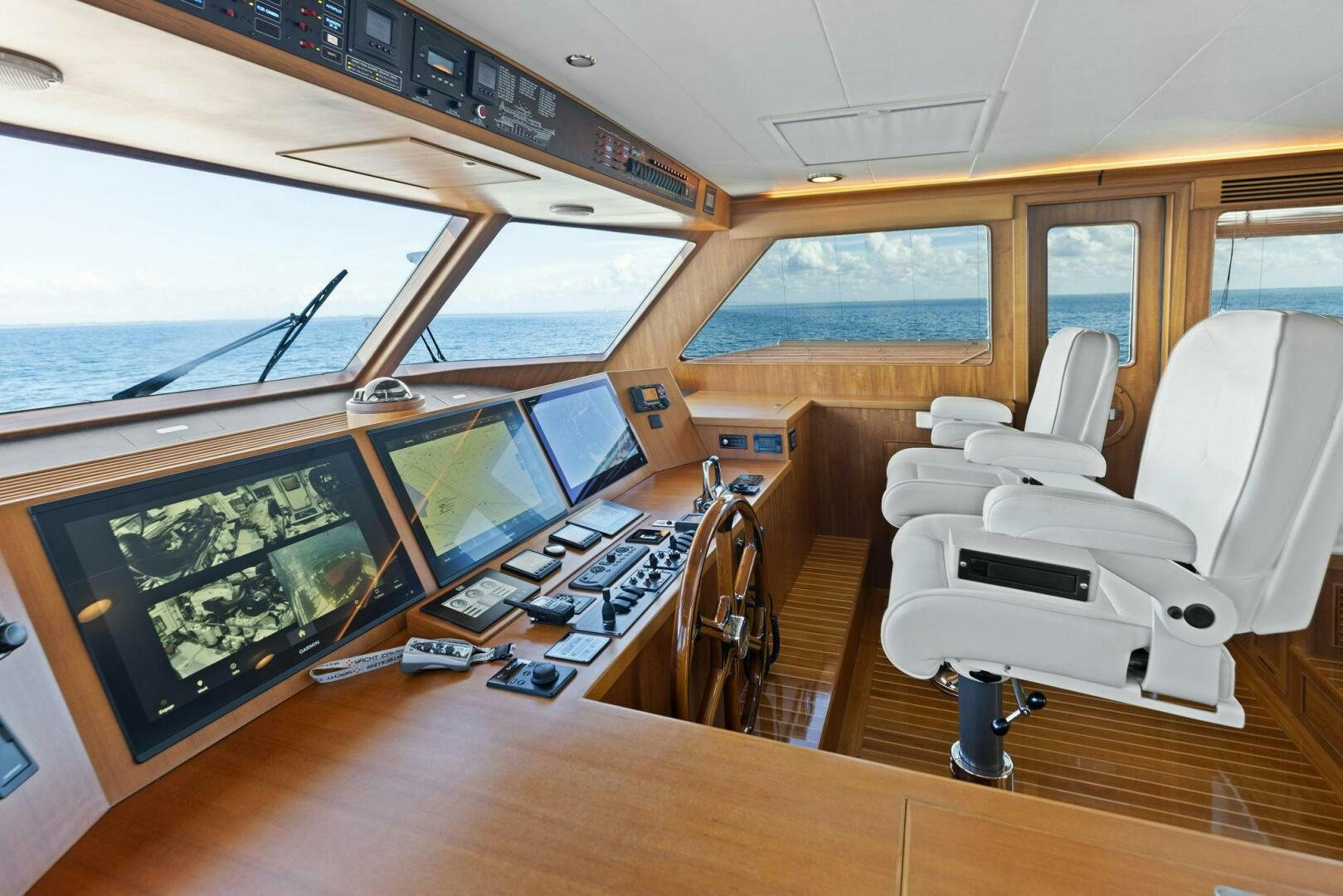 a room with a large window and a table with chairs and computers aboard SUNZSET Yacht for Sale