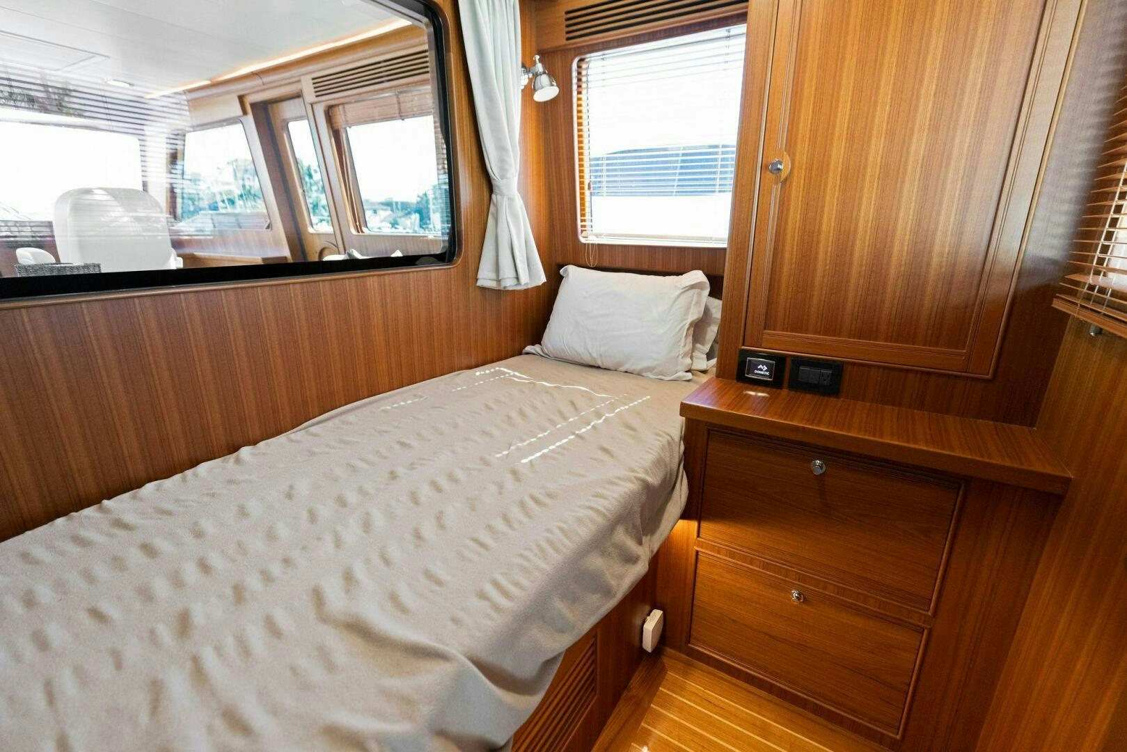 a bedroom with a bed and a dresser aboard SUNZSET Yacht for Sale