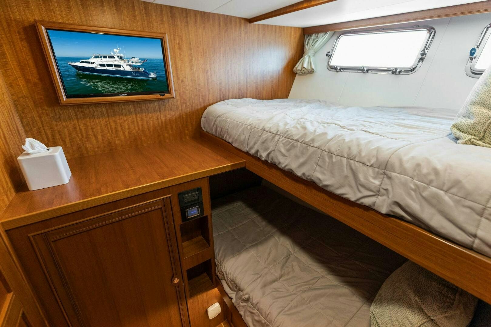 a bed with a television on the wall aboard SUNZSET Yacht for Sale