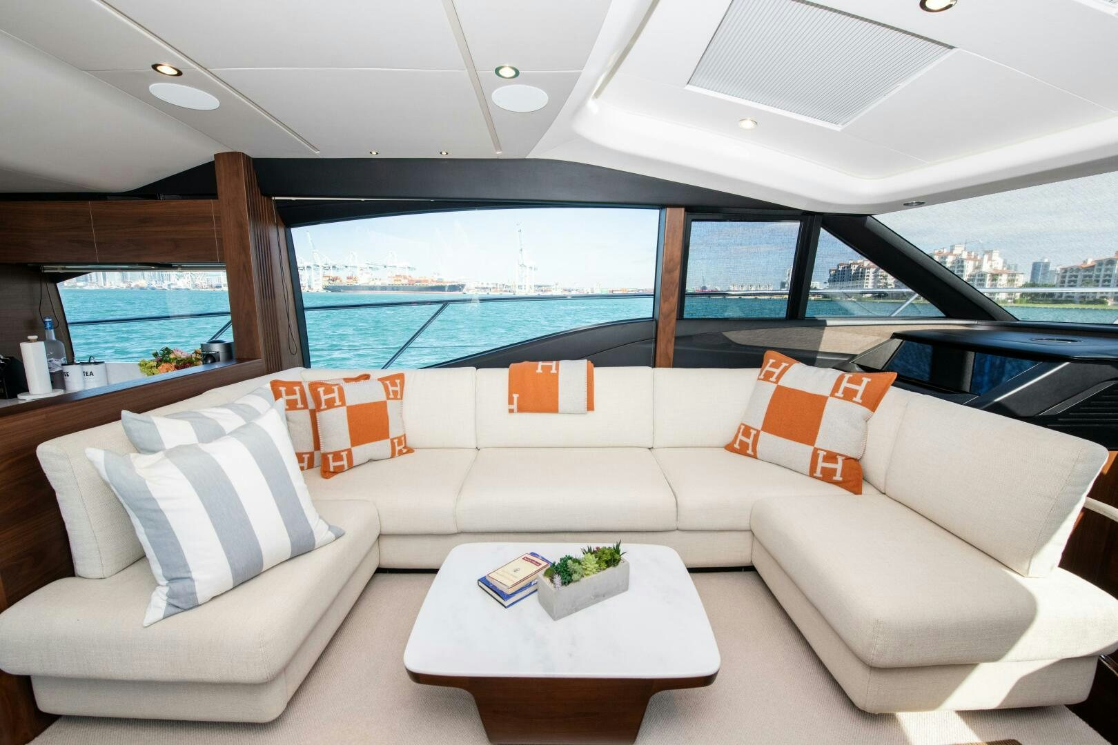 a white couch and a table in a room with a large window aboard LADY D Yacht for Sale