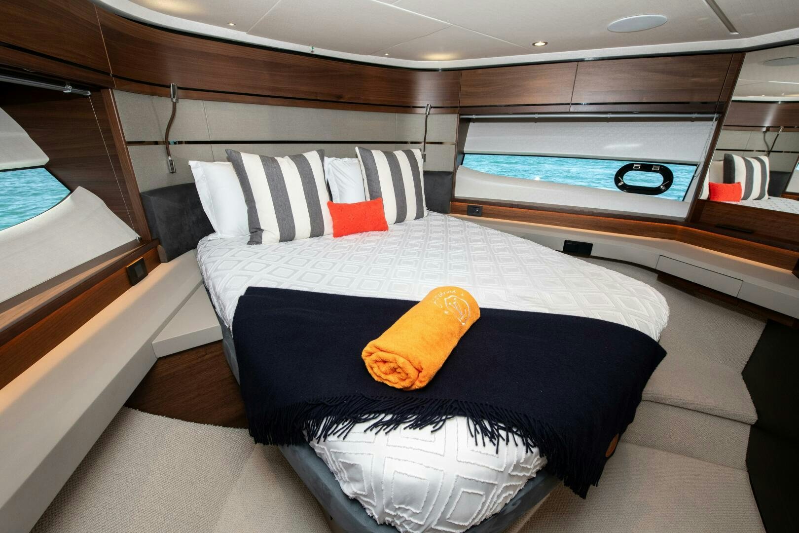 a bed with a blue and white blanket and pillows aboard LADY D Yacht for Sale