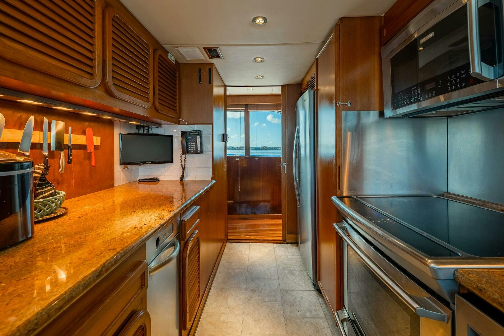 a kitchen with wooden cabinets aboard TRILOGY Yacht for Sale