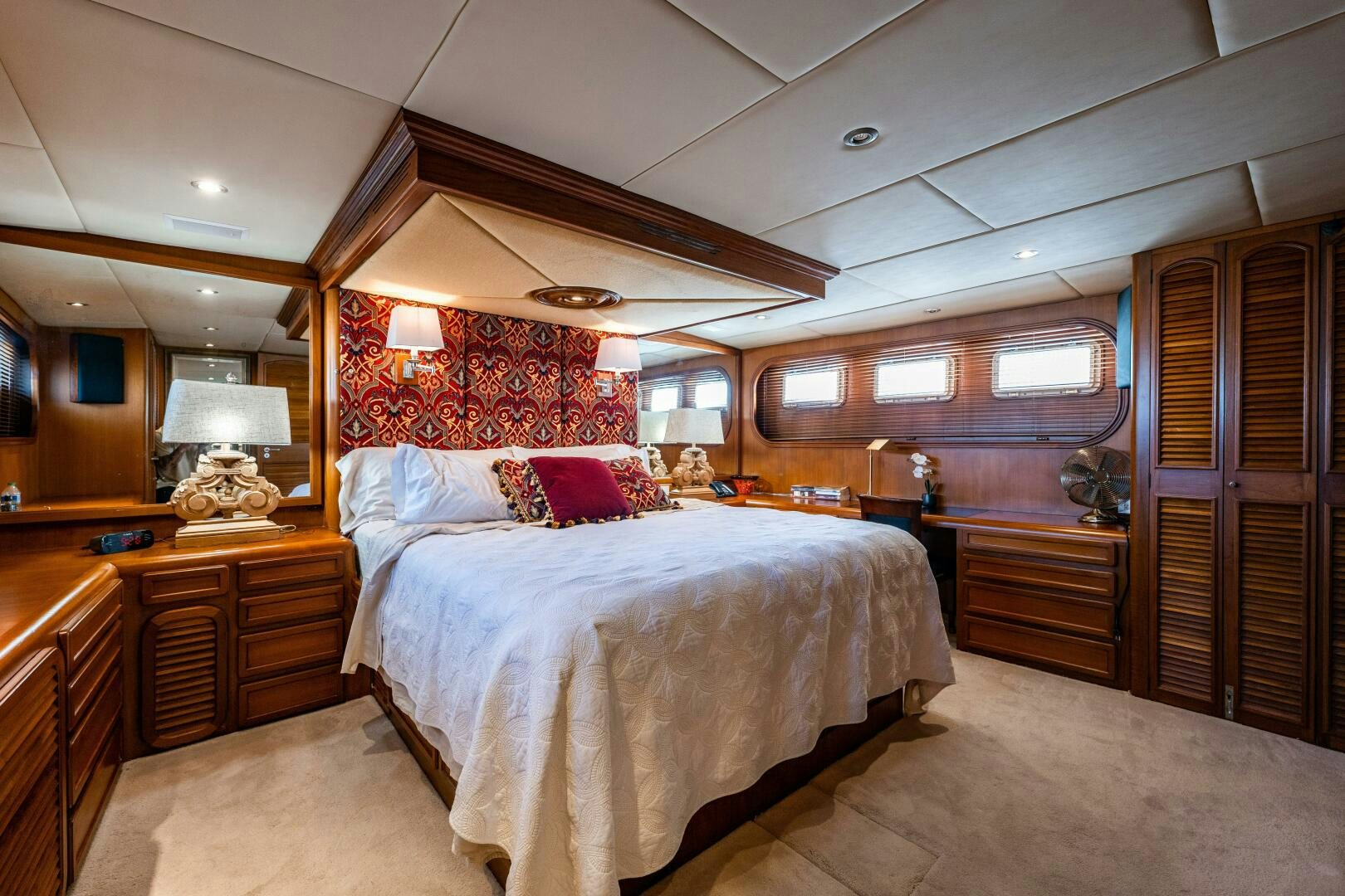 a bedroom with a bed and a dresser aboard TRILOGY Yacht for Sale