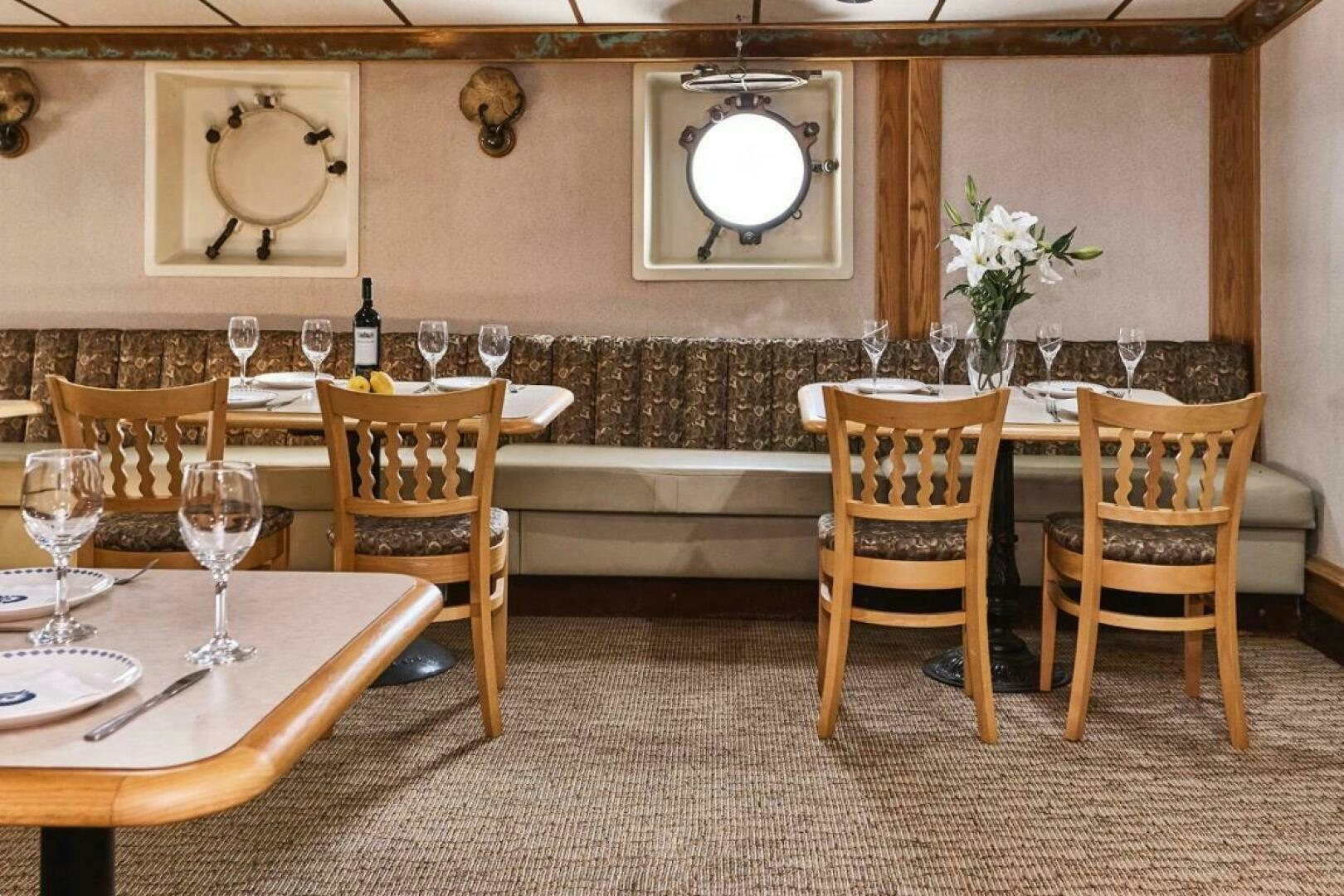 a room with tables and chairs aboard SALTY Yacht for Sale