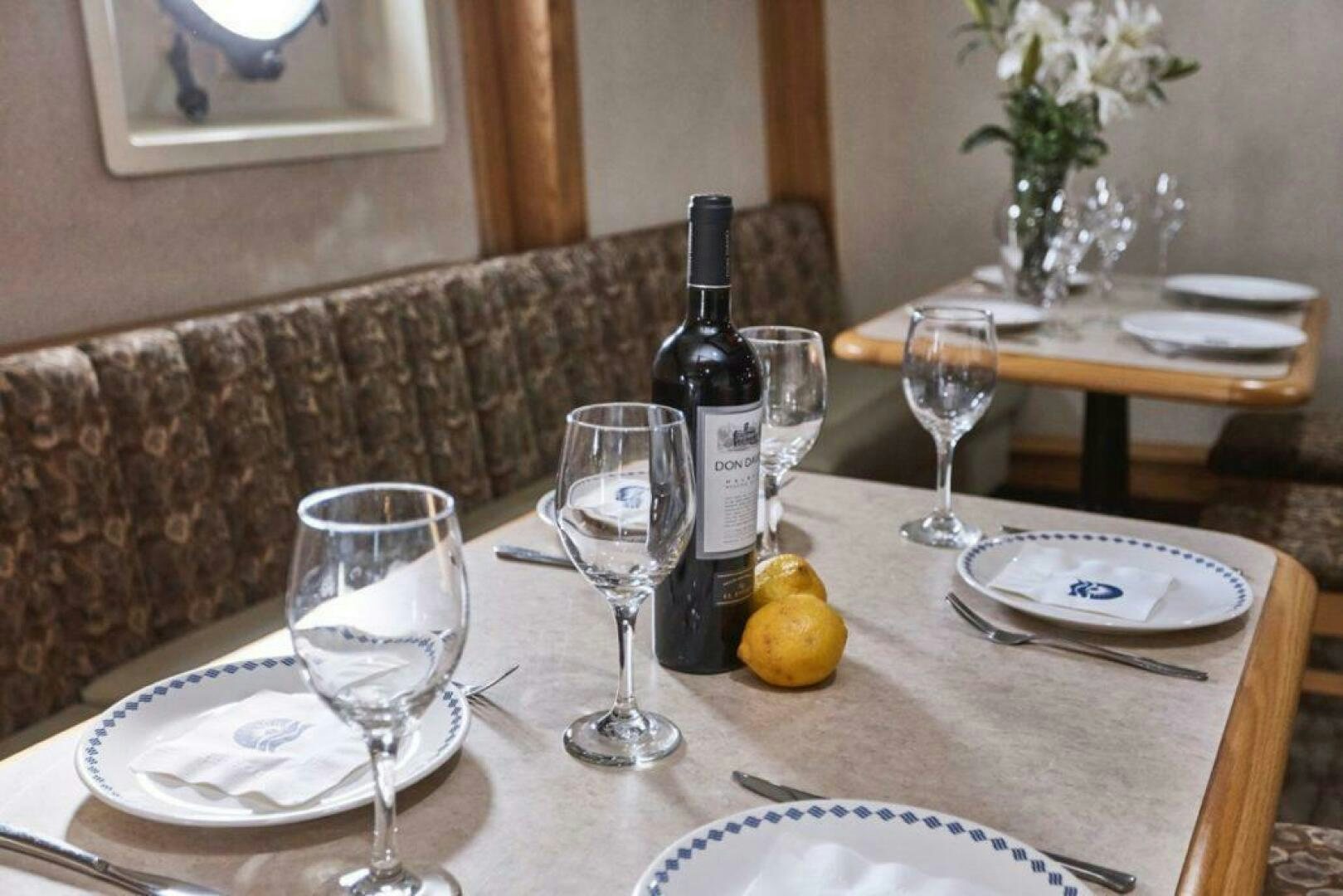 a table with wine glasses and bottles aboard SALTY Yacht for Sale