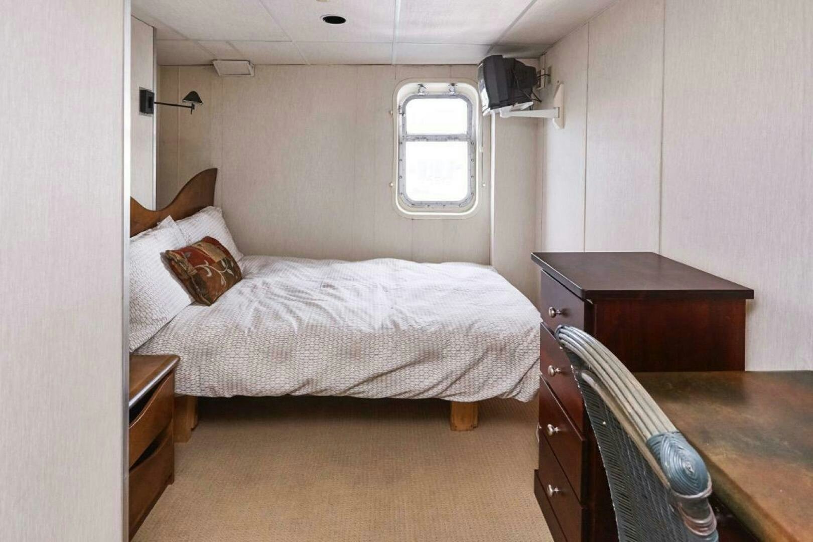 a bedroom with a bed and a desk aboard SALTY Yacht for Sale
