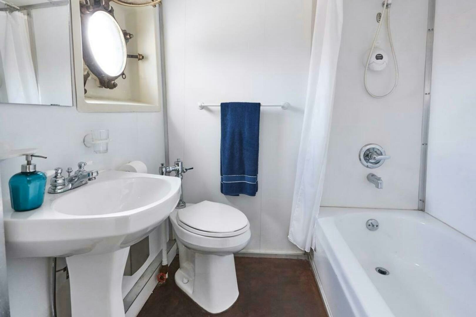 a bathroom with a tub sink and toilet aboard SALTY Yacht for Sale