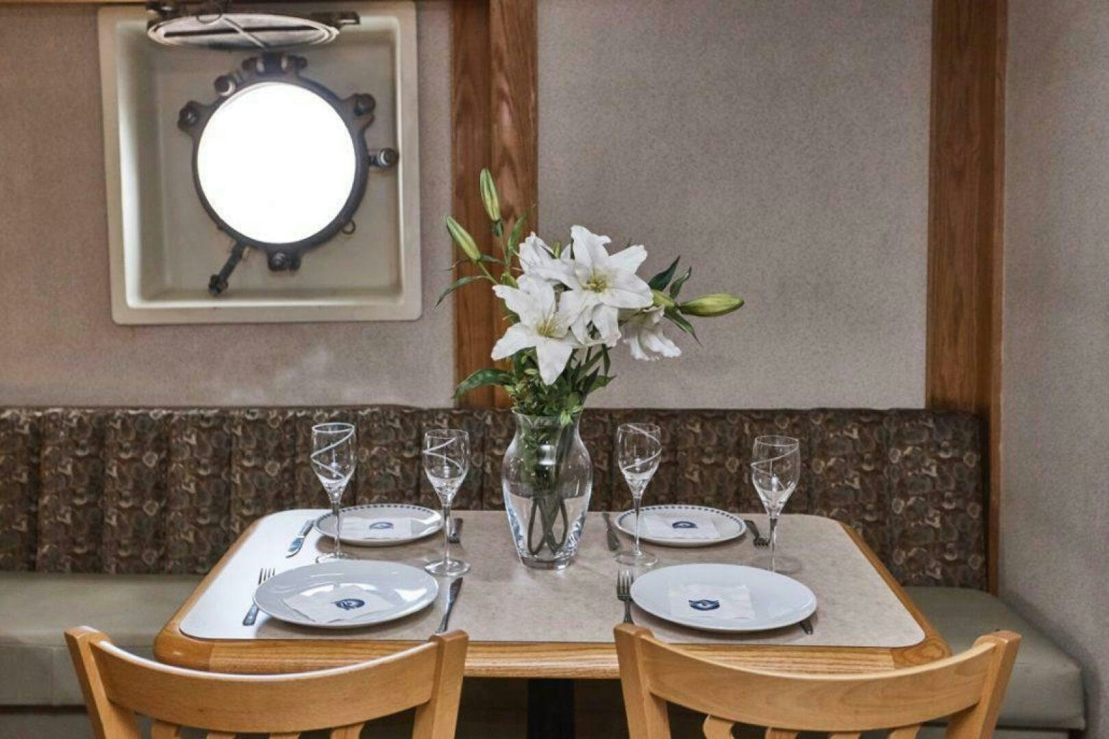 a table with plates and glasses aboard SALTY Yacht for Sale
