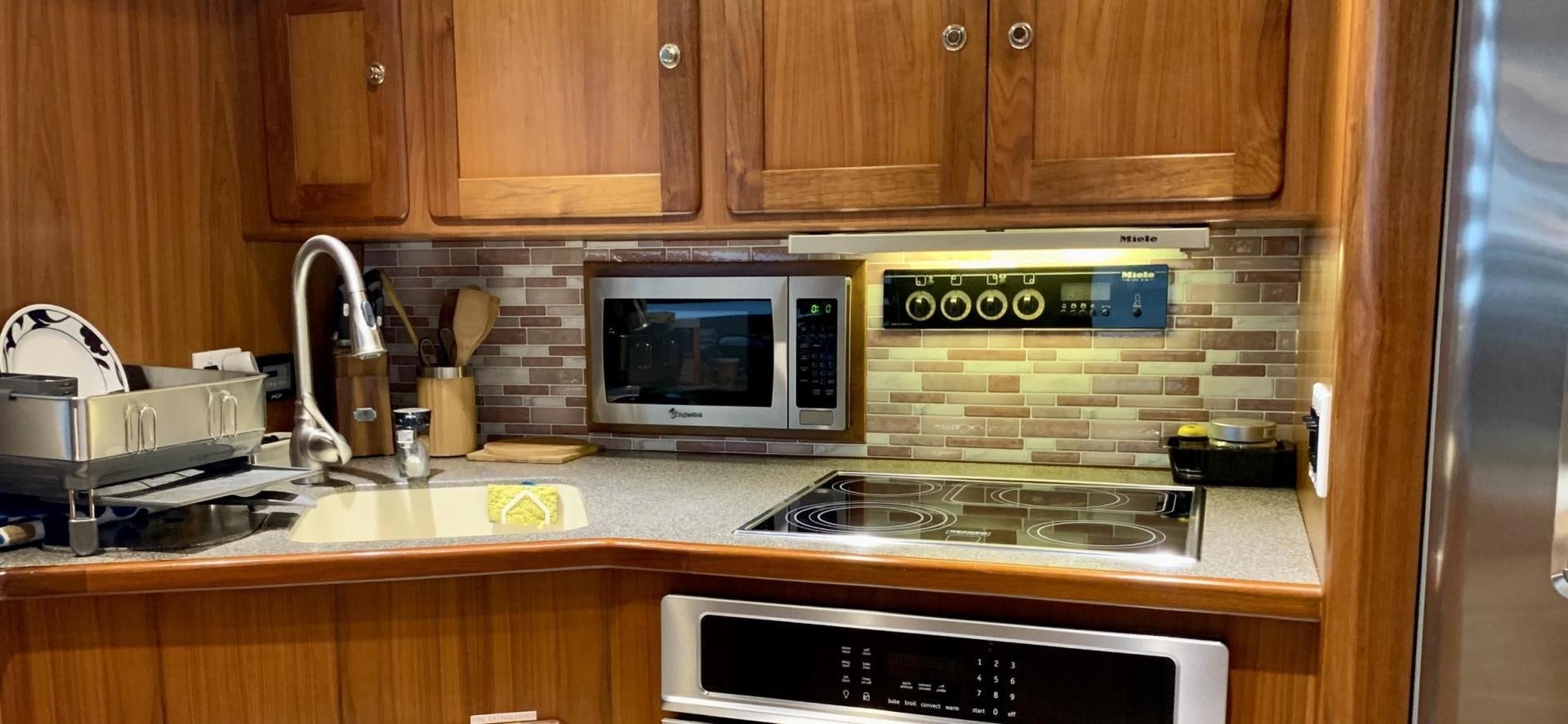 a kitchen with wooden cabinets aboard OBSESSION Yacht for Sale