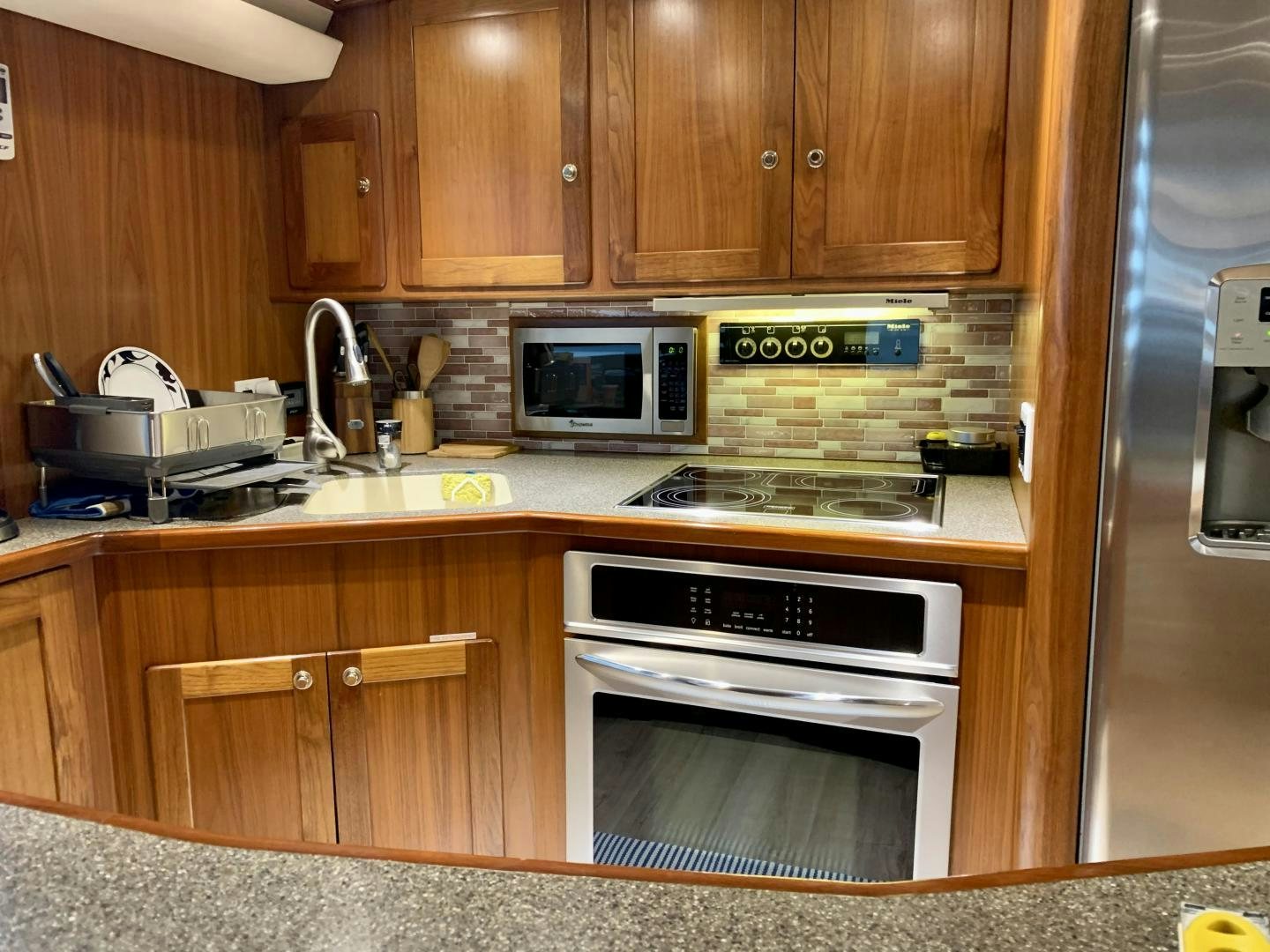 a kitchen with wooden cabinets aboard OBSESSION Yacht for Sale
