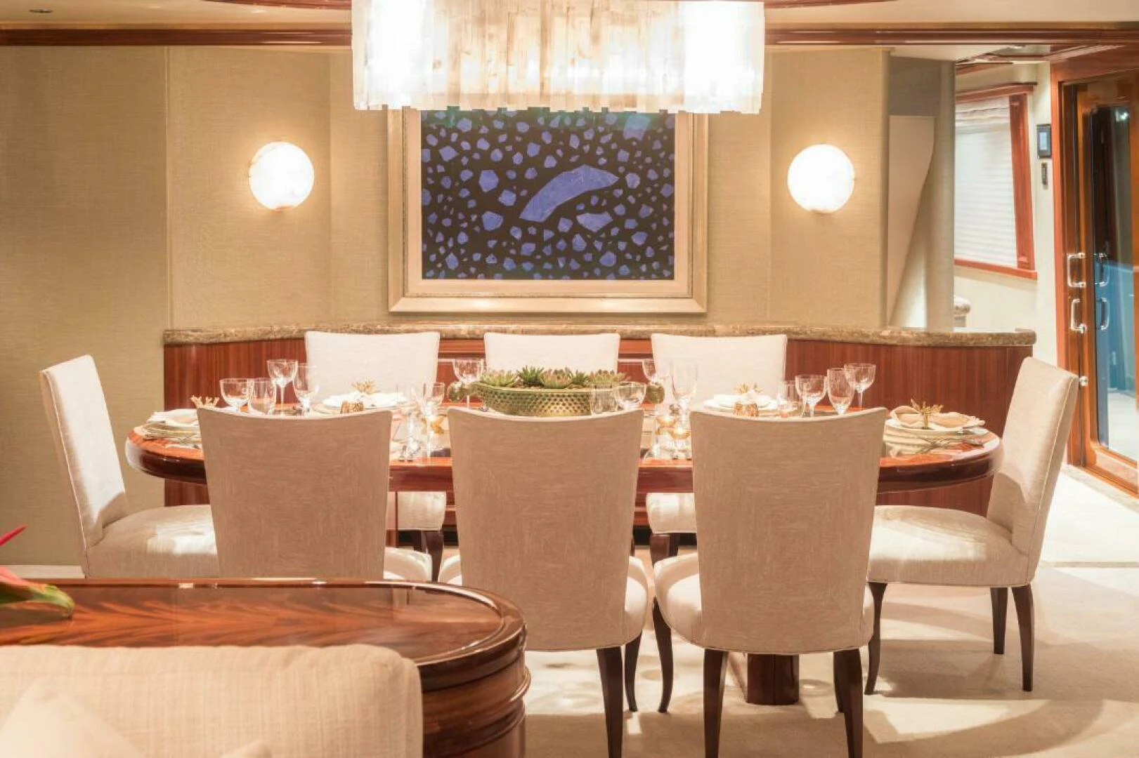 a dining room table with chairs and a large chandelier aboard ALL INN Yacht for Sale